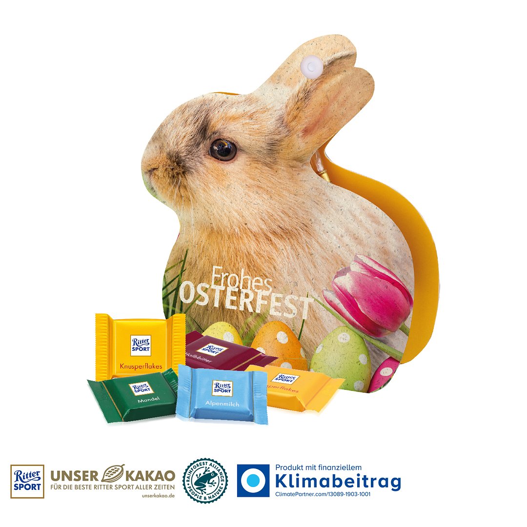 Werbe-Hase mit Ritter SPORT Schokotäfelchen auf Graspapier