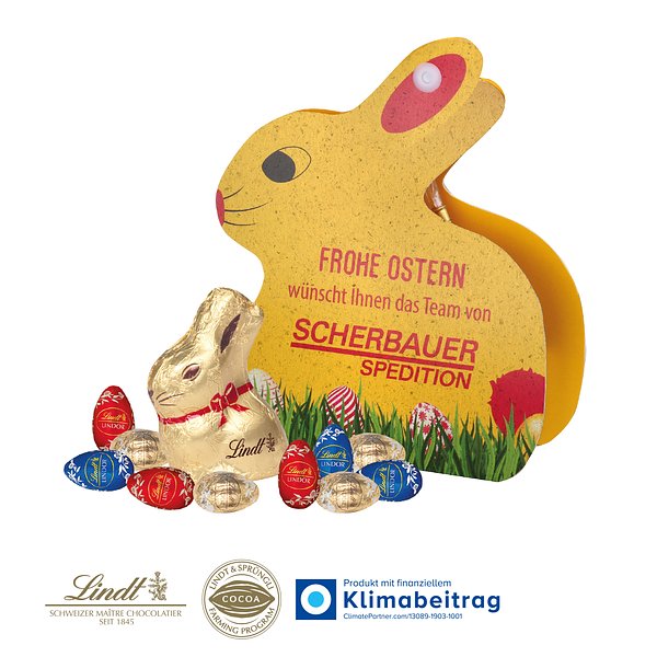 Werbe-Hase mit Goldhase und Schoko-Eier von Lindt auf Graspapier